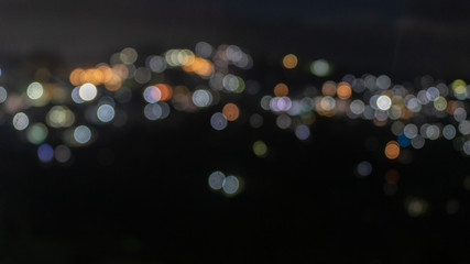 Blurry city lights of a town situated in hill.