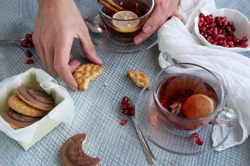 Refreshment time, Top view of woman hands holding a tasty homemade biscuits and pomegranate tea