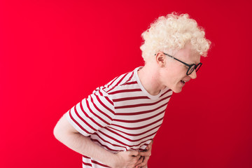 Young albino blond man wearing striped t-shirt and glasses over isolated red background with hand...