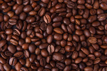 Beautiful composition of coffee beans, utensils for making coffee and decor in the form of almonds, dried slices of lemon, peanut and cinnamon on black and blue backgrounds.