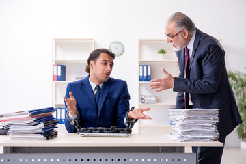 Old boss and young male employee in the office