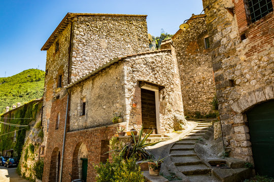 A glimpse of the small village of Stifone, on the Nera river. A cobblestone alley between the stone houses. A staircase. The walls of stones and bricks. Umbria, Terni, Italy