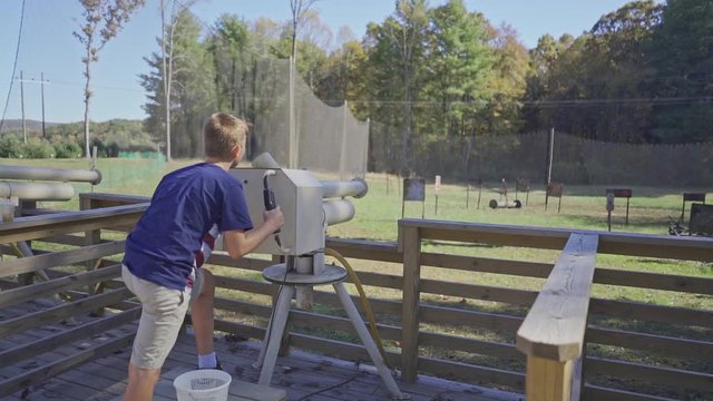 Young boy shooting apple canon in apple orchard