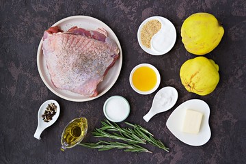 Prepared ingredients for cooking baked turkey with quince: raw turkey thigh, quince, sugar, honey, salt, spices, olive oil, butter, rosemary. Thanksgiving Recipes.