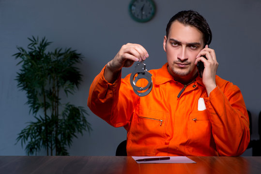 Young convict man sitting in dark room