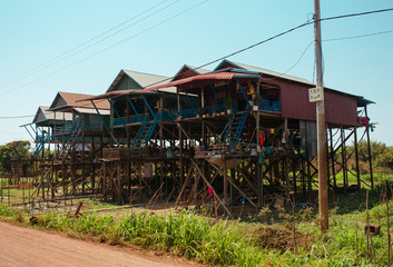 Floating village Residential houses on wooden poles and red soil road in Kampong Phluk Cambodia near Tonle Sap Lake