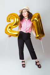 A young girl with balls that show the number twenty one. Birthday.