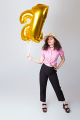 The girl in the hat holds balloons