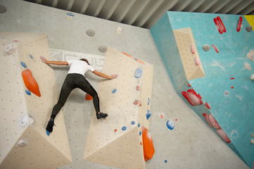 Frau bouldert einen Parkour in einer Boulderhalle