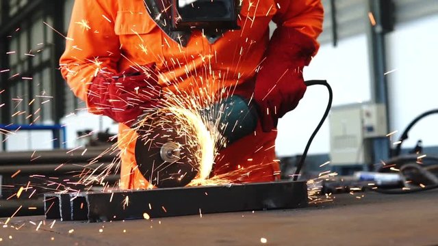 Electric wheel grinding on steel structure in factory 