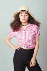 Stylish girl in a pink plaid shirt and black trousers.