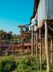 Fototapeta na wymiar Floating village Residential houses on wooden poles and red soil road in Kampong Phluk Cambodia near Tonle Sap Lake