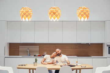 Portrait of caucasian family, wife and husband sit together at table. Woman put her head on man shoulder. Happy family, love, relationship concept