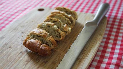 Rebanas de pan y cuchillo de sierra sobre tabla de madera