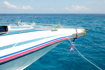 Speed boat nose against blue waves in sunny weather