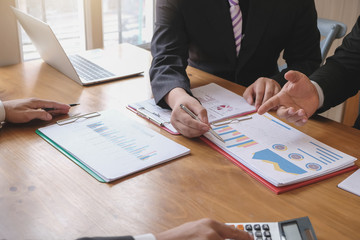 Businessman pointing hand at the data graph to analyze and planning financial and investment strategy at meeting.
