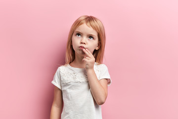 serious pensive girl with a finger on her chin looking up, close up photo. isolated pink background, idea, plan , faciala expression, reaction - Powered by Adobe
