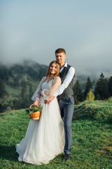 Groom with a bride or couple on a background of a beautiful mountain landscape. Wedding in the...