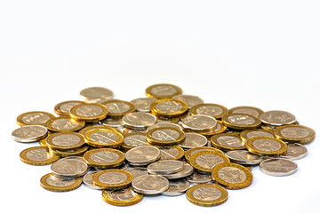 photo of Belarusian money on a white background. Coins in denominations of one ruble and two rubles are scattered on the surface and isolated on a white background.