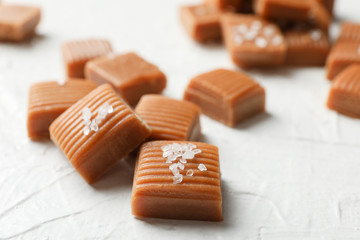 Salted caramel candies on white background, closeup and copy space