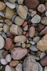 Fototapeta na wymiar smooth colorful pebbles on the beach background