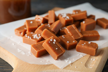 Salted caramel candies on wooden board, close up and copy space