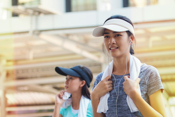 Young female running with friend or jogging in the city street