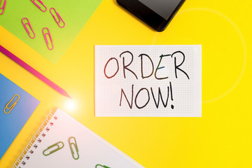 Writing note showing Order Now. Business concept for confirmed request by one party to another to buy sell Paper sheets square notebook pencil clips smartphone colored background