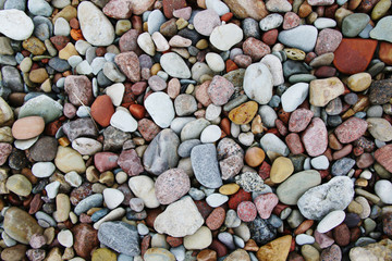 smooth colorful pebbles on the beach background