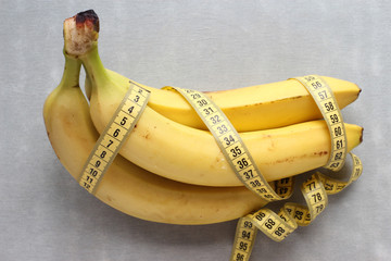 Banana and measure tape on grey background