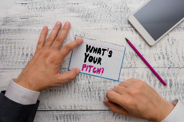 Conceptual hand writing showing What S Is Your Pitch question. Concept meaning asking about property of sound or music tone Hand hold note paper near writing equipment and smartphone