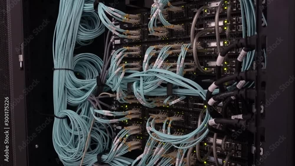 Aufkleber severs computer in a rack at the large data center. many optical cable. motion camera