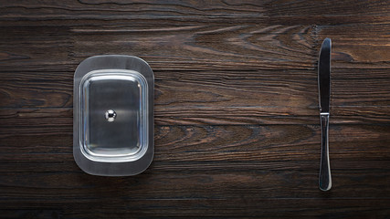 butter in butter dish on wooden background. top view