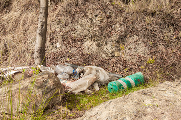 Packages left on the banks of a river, polluting the environment
