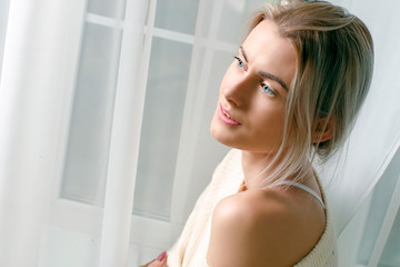 Fototapeta na wymiar portrait of a young beautiful girl in a white sweater in the studio