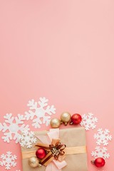 Close up shot of small gift wrapped with ribbon on pink background. Christmas background. Minimal concept. Flat lay. Top view