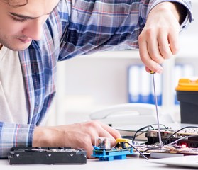 Professional repairman repairing computer in workshop