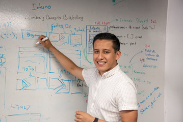 joven empresario latino en oficina, startup, lluvia de ideas y videojuegos - obrazy, fototapety, plakaty