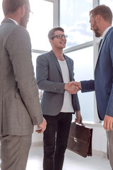 business people greet each other in the office lobby