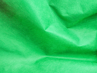 Abstract background of wrinkle pattern, vivid or vibrant green paper texture.