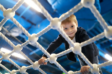 Boy crawling on rope net
