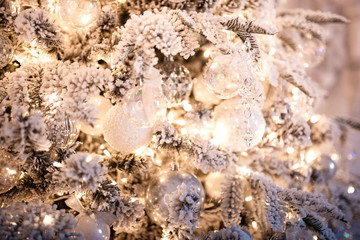 Christmas tree branch with decorations New Year gift ball snowflakes close up, silver white color