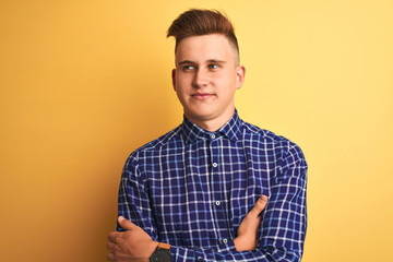 Young handsome man wearing casual shirt standing over isolated yellow background smiling looking to the side and staring away thinking.