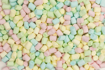 background of tiny marshmallows in yellow, green, blue and pink