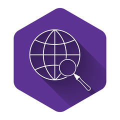 White Magnifying glass with globe icon isolated with long shadow. Analyzing the world. Global search sign. Purple hexagon button. Vector Illustration