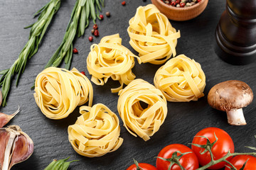 tagliatelli with vegetables on a slate black board