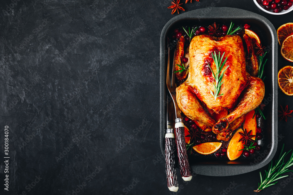 Wall mural roasted chicken or turkey with spices, oranges and cranberries for christmas or thanksgiving