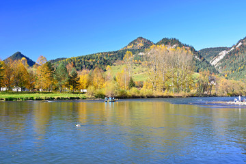 Raft with tourist on Dunajec river in autumn landscape of Pieniny mountains