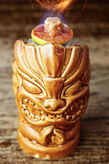 Cocktail in a glass tiki on the bar