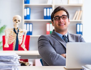 Businessman working with skeleton in office